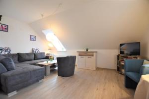 ein Wohnzimmer mit einem Sofa und einem TV in der Unterkunft Haus Antje-Kellenhusen Whg2 in Kellenhusen