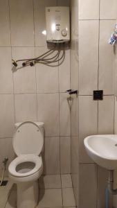 a bathroom with a toilet and a sink at Apartemen Grand Kamala Lagoon Bekasi By Cicie Room in Pekayon Satu