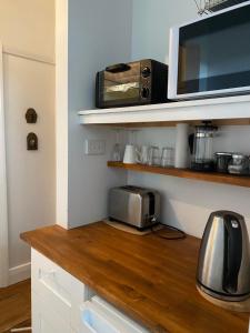 a kitchen with a counter with a toaster and a microwave at Aashay Country Stay in Fish Creek