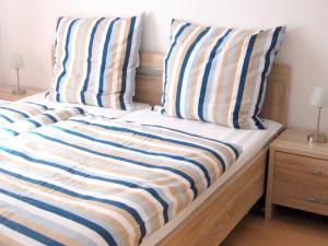 グレーミッツにあるFerienwohnungen Öker - Stadtvilla OGのベッド(青と白のストライプの枕付)