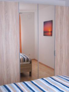 - une chambre avec un placard en verre et un lit dans l'établissement Ferienwohnungen Öker - Stadtvilla OG, à Grömitz