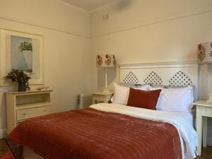 a bedroom with a large bed with a red blanket at Aashay Country Stay in Fish Creek