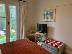 a bedroom with a bed and a tv and a window at Aashay Country Stay in Fish Creek