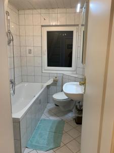 uma casa de banho com uma banheira, um WC e um lavatório. em Moderne 2 Zimmer Wohnung mit Vollausstattung em Ketsch