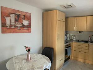 a kitchen with a table and a vase of flowers on it at Moderne 2 Zimmer Wohnung mit Vollausstattung in Ketsch