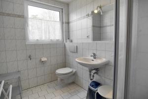 ツィングストにあるReisenauerの白いバスルーム(トイレ、シンク付)