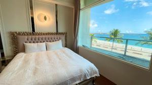 1 dormitorio con ventana y vistas a la playa en Angel Inn, en Hualien City