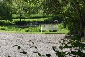 una panchina bianca seduta in mezzo a un parco di Muschelkorb a Hinrichsdorf