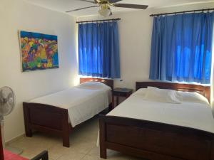 1 dormitorio con 2 camas y ventilador de techo en Cita del Sol City Apartments, en Cabarete