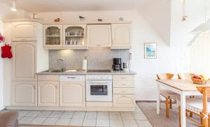 KronsgaardにあるAusguck - 93812の白いキャビネットとテーブル付きのキッチン