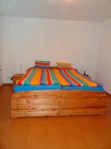 una camera con letto in legno e coperte colorate di FeWo im Schobeck a Hanerau-Hademarschen