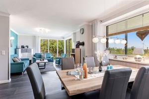 a dining room and living room with a table and chairs at Relax Bungalow Strandperle in Klausdorf