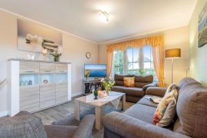 un soggiorno con 2 divani e una TV di Ferienhaus Rose - 51656 a Klausdorf