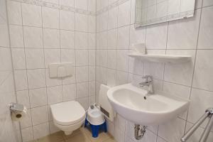 a white bathroom with a sink and a toilet at Am Deich 32 in Zingst