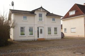 a white house with white doors and windows at Dünung in Kellenhusen