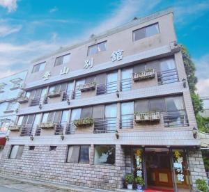 a tall brick building with windows and balconies at 登山別館 in Zhongzheng