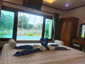 A bed or beds in a room at Baan Nai Daeng Villa /Baannaidaengvilla