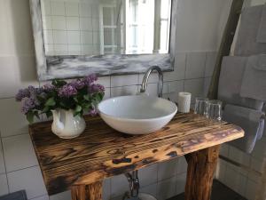 een badkamer met een witte wastafel op een houten tafel bij Kellerstöckl am veganen Bio-Lebenshof "Varm - die vegane Farm" in Sulb