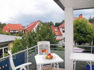 een witte stoel op een balkon met een fruitschaal bij Meeresbrise in Neuhaus