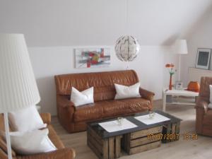 パーペンブルクにあるFerienwohnung Marimのリビングルーム(ブラウンレザーのソファ、コーヒーテーブル付)
