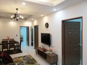 a living room with a flat screen tv on a wall at Onies Homestay Lumut Manjung in Lumut