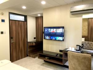 a hotel room with a television on the wall at Meenakshi Inn in Udupi