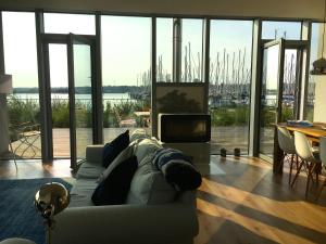 a living room with a couch and a view of a harbor at Ostsee - Reetdachhaus Nr 46 "Strandrausch" im Strand Resort in Heiligenhafen