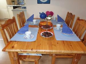 a wooden table with blue napkins and food on it at Tante Anna in Hasselberg