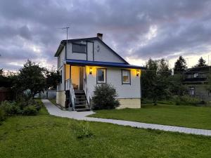 una casa bianca con un tetto blu su un prato di просто хорошая дача a Kokkozenkkolka