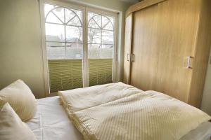 an unmade bed in a bedroom with a window at Villa Vogelsang, FW 2 in Zingst