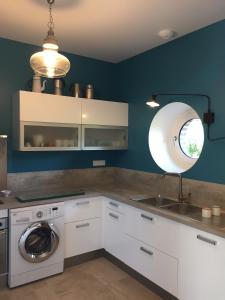 eine Küche mit einer Waschmaschine und einem Waschbecken in der Unterkunft Gîte LA MELINOTHE - 12 personnes - Grand gîte de charme indépendant 5 étoiles in Paisy-Cosdon