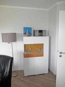 a white cabinet in a room with a lamp at "Landhaus Voss" Typ 4 Nr11 in Staberdorf
