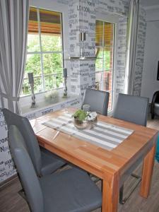a dining room with a wooden table and chairs at "Landhaus Voss" Typ 4 Nr11 in Staberdorf