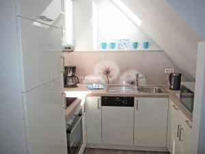 a small kitchen with white cabinets and a sink at "Landhaus Voss" Typ 4 Nr11 in Staberdorf