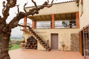 a house with a staircase in front of a building at Masia Can Castanyola in Marganell