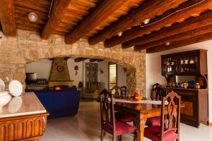 a kitchen and dining room with a stone wall at Masia Can Castanyola in Marganell