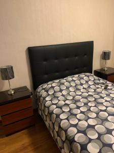 a bedroom with a bed with a black headboard and two lamps at Host - San Isidro Sta Catalina in Lima