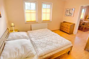 a bedroom with a bed and a dresser and two windows at Gerlach in Zingst