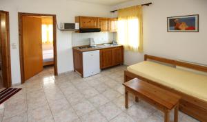 Habitación con cocina con cama y mesa. en Nama Apartments, en Skala Potamias