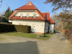 a white house with an orange roof and a driveway at Fewo 4 Friedenstraße in Zingst