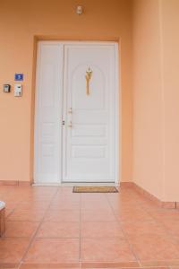 eine weiße Tür mit einem Kreuz darauf in der Unterkunft Zara's Home Meteora-A Home With A View! in Kalambaka