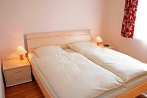 - une chambre avec un lit, 2 tables de nuit et 2 lampes dans l'établissement "Landhaus Voss" Typ 2 Nr7, à Staberdorf