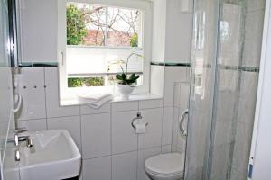 La salle de bains est pourvue de toilettes, d'un lavabo et d'une fenêtre. dans l'établissement "Landhaus Voss" Typ 2 Nr7, à Staberdorf