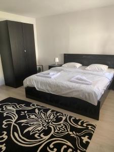 una camera con un letto e un tappeto bianco e nero di Casa Antonia Busteni a Buşteni