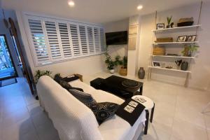 a living room with two white chairs and a couch at LILY LAMOND, T/House, outdoor shower, 5 min walk to the ocean, Airlie Beach in Airlie Beach