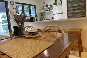 a dining room table with two chairs and a wooden table at LILY LAMOND TOWNHOUSE, outdoor hammock, 5 min walk to the ocean, in Airlie Beach in Airlie Beach