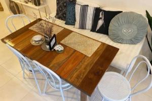 a wooden table with two chairs and a couch at LILY LAMOND TOWNHOUSE, outdoor hammock, 5 min walk to the ocean, in Airlie Beach in Airlie Beach