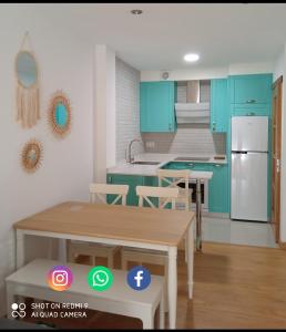 cocina con armarios azules, mesa y sillas en El pisito de Lourizan en Pontevedra