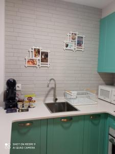 cocina con fregadero y microondas en El pisito de Lourizan en Pontevedra