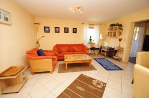 ein Wohnzimmer mit einem orangenen Sofa und einem Tisch in der Unterkunft Rudow in Dahme